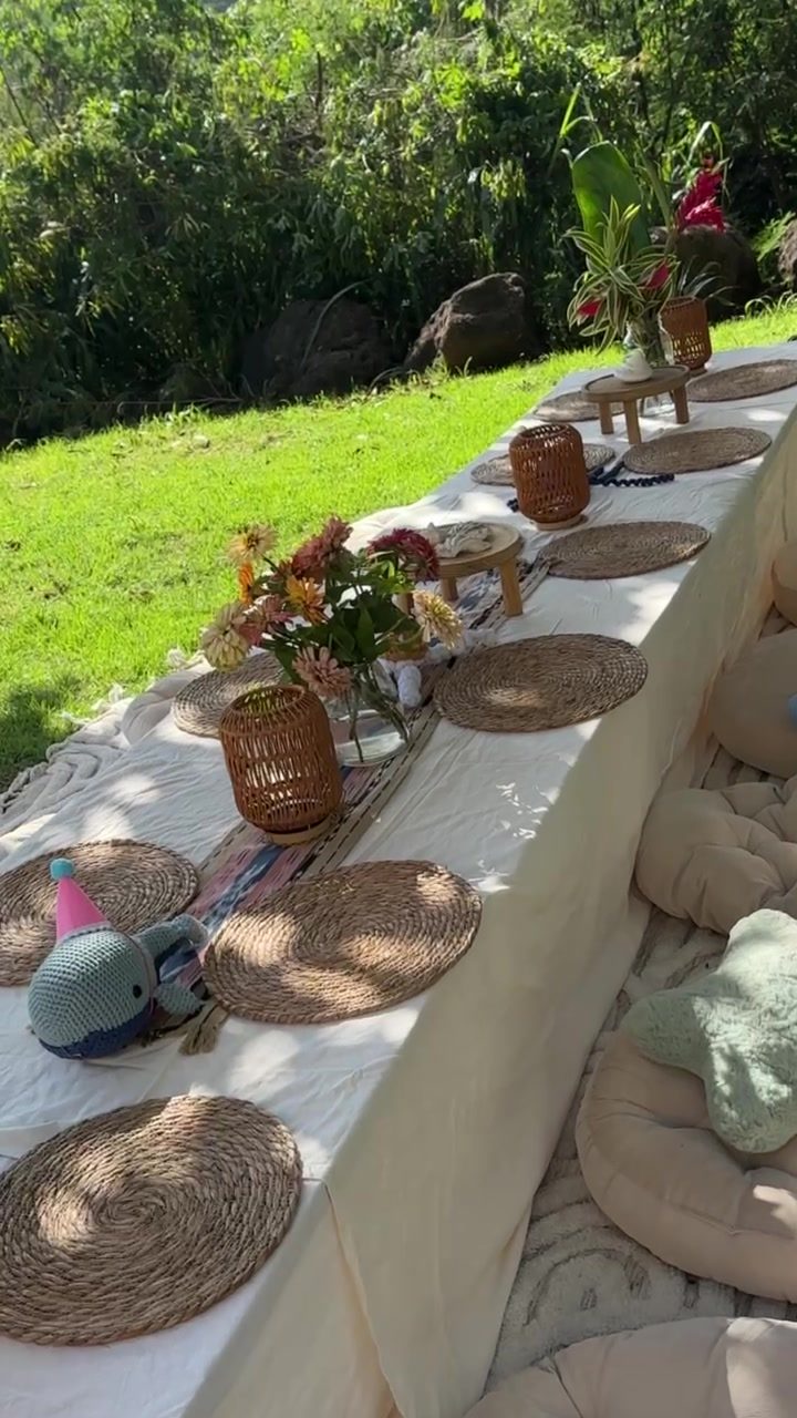 Lawn tablescape with florals, woven chargers and starfish cushions