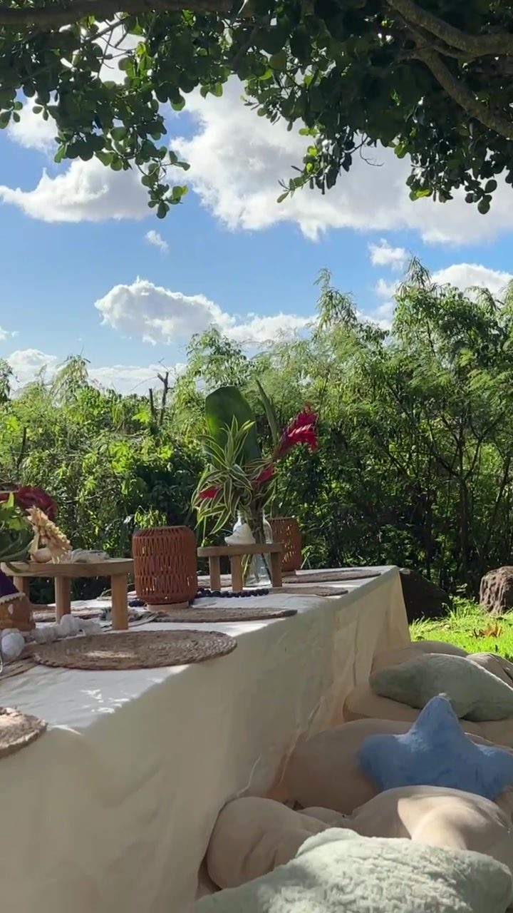 Long birthday table set under the trees with ocean views