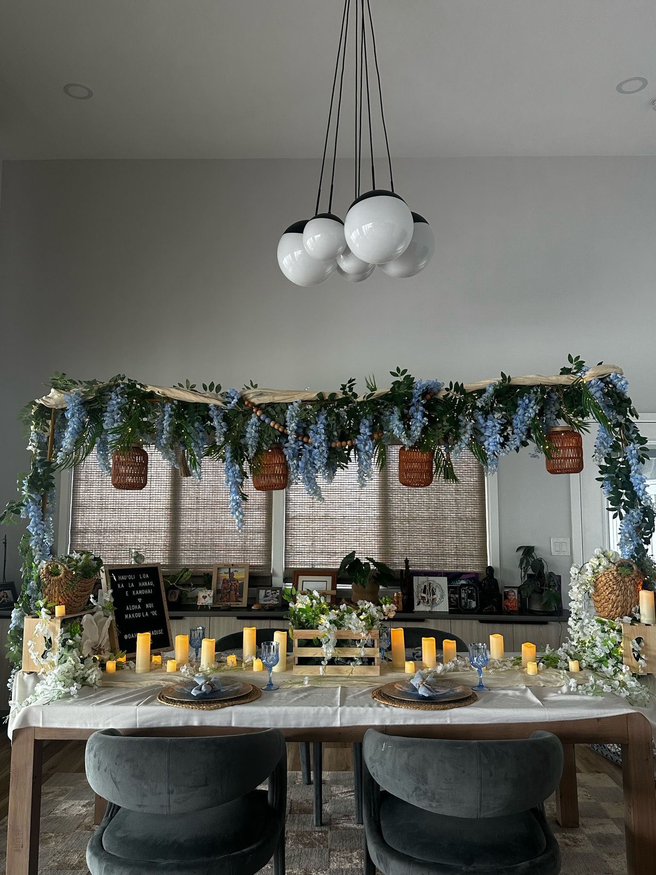 Private dinner table under a hanging wisteria canopy with candles