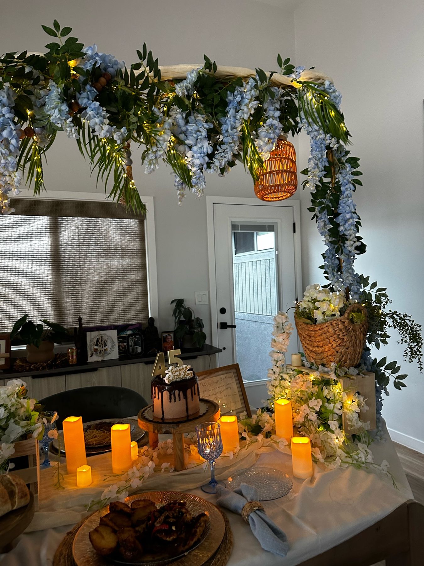 Wisteria garland, rattan lanterns and a flower basket over the dinner table
