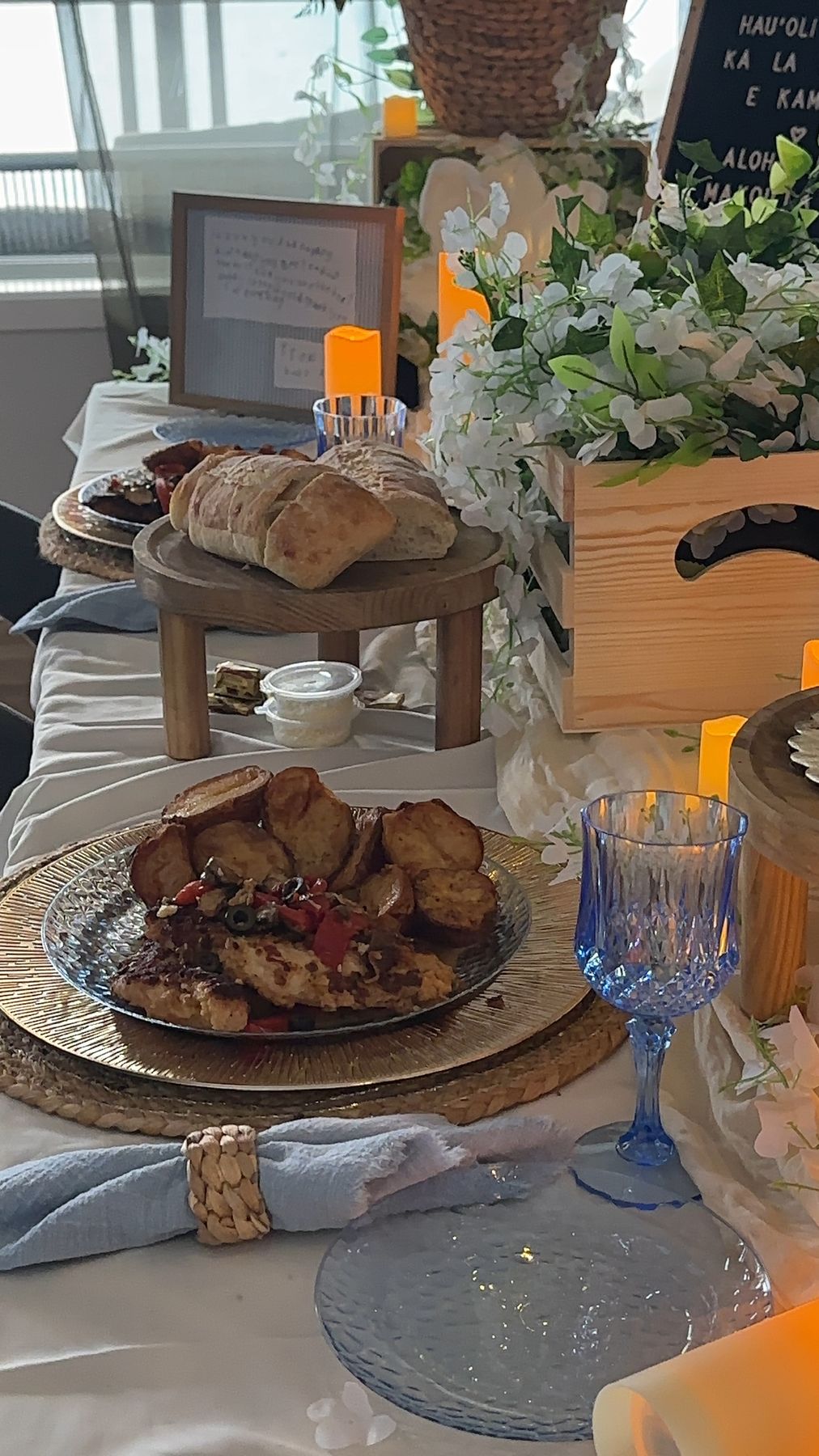 Plated dinner on a woven charger with blue goblet and gold napkin ring