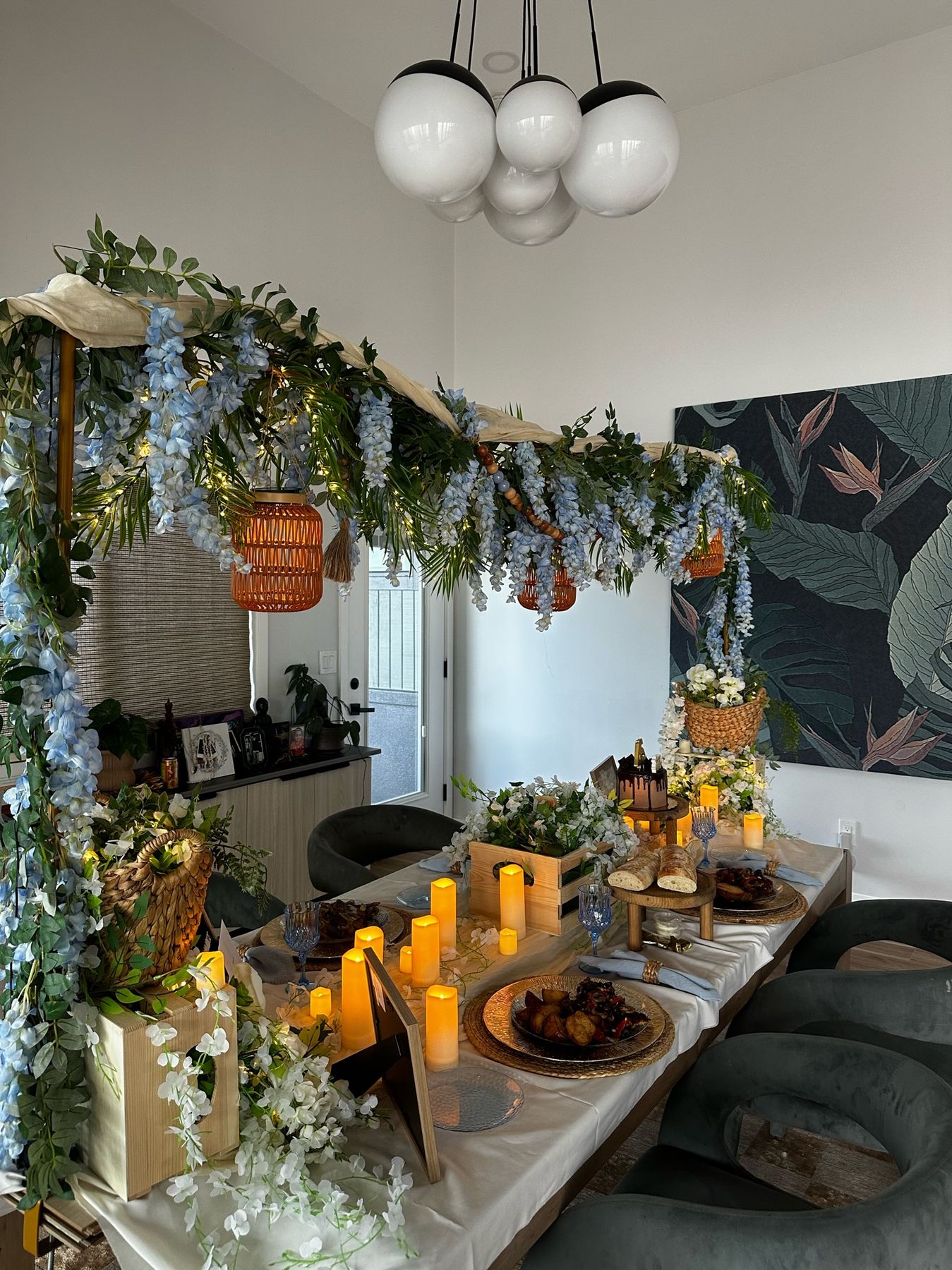 Wisteria and lantern canopy framing the candlelit dinner table
