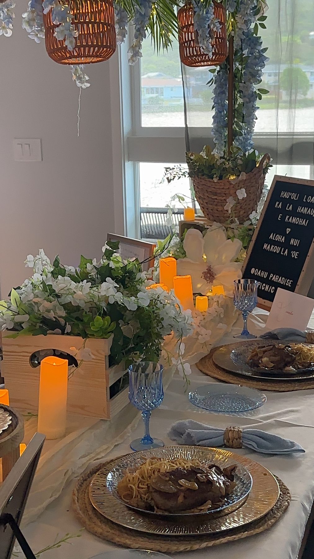 Place setting with blue goblet beside candles and a custom letterboard