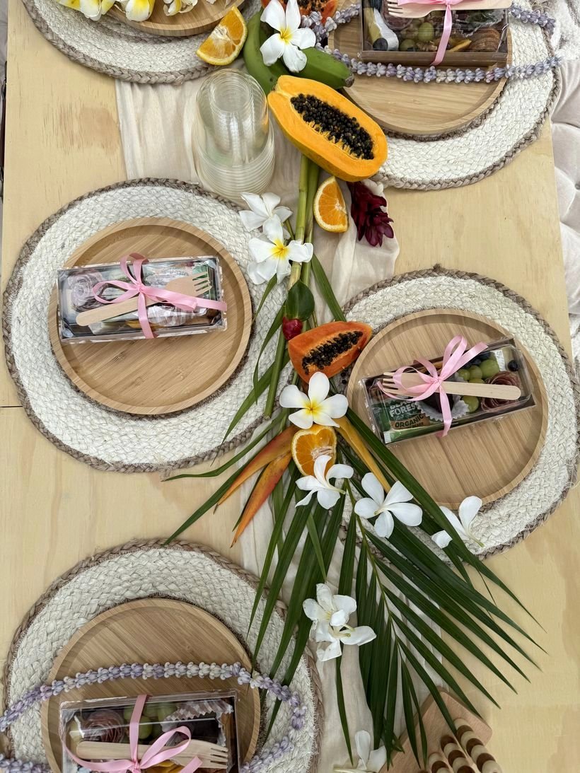 Tropical runner of palm, plumeria and orange slices across the wooden table