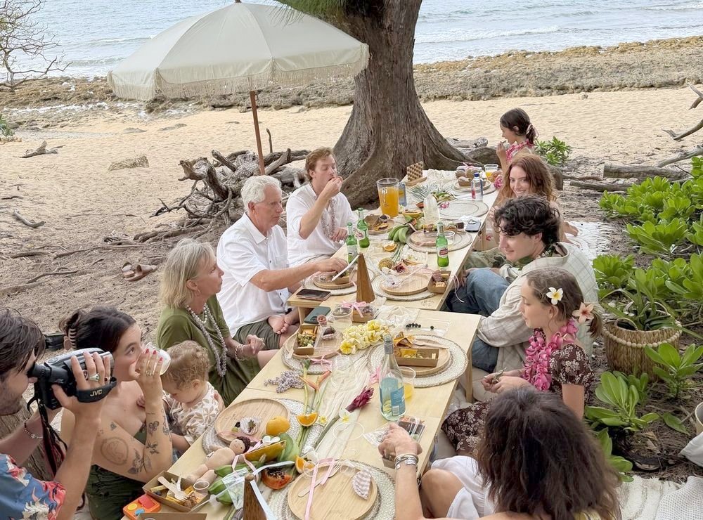 The whole family gathered around the long oceanfront picnic table