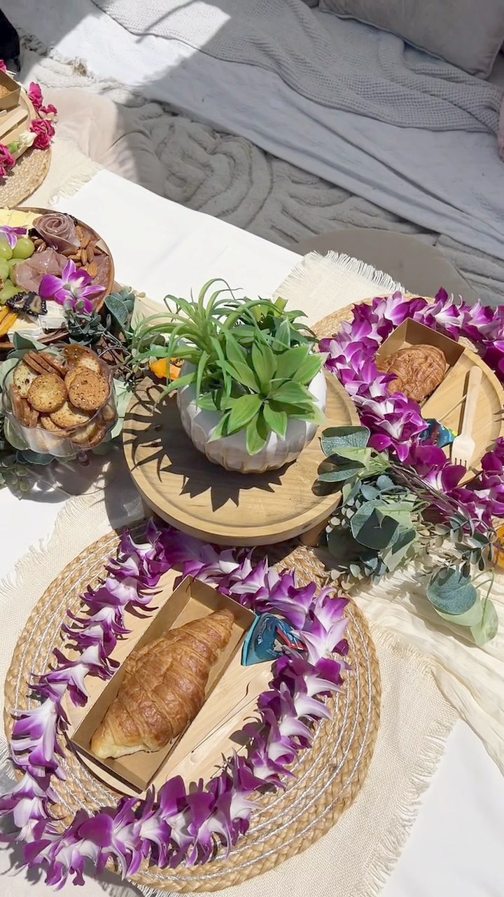 Purple orchid leis wrapped around pastry boards and a succulent centerpiece