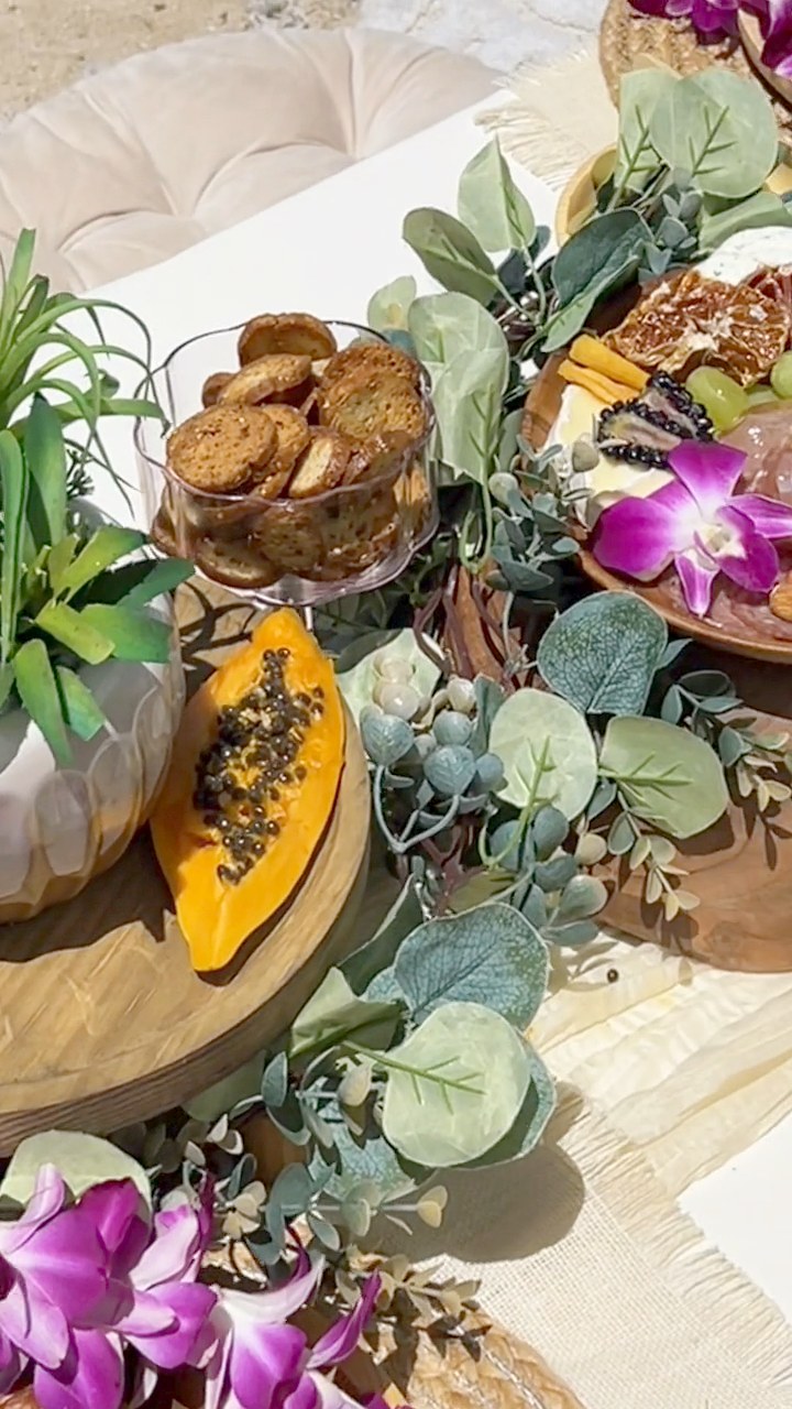 Papaya, cookies and charcuterie nestled in eucalyptus and orchids