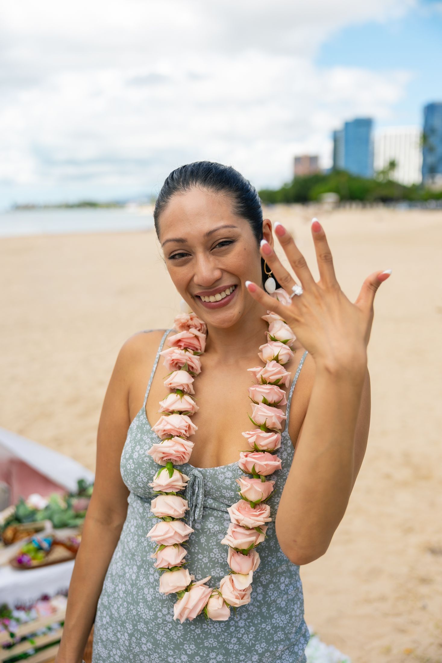 Emily shows her engagement ring wearing a pink flower lei