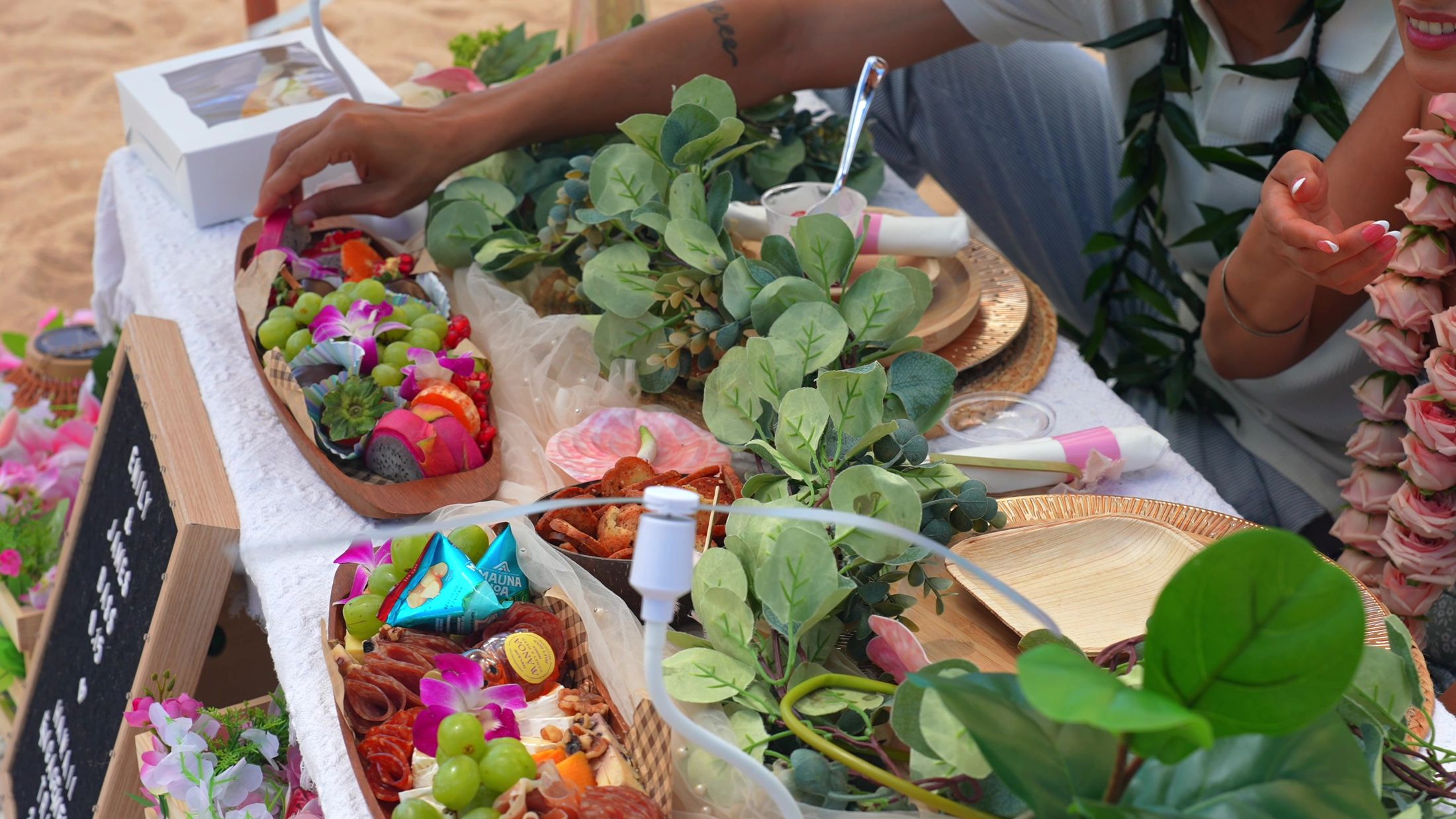 The couple reaching into the orchid-topped grazing boards