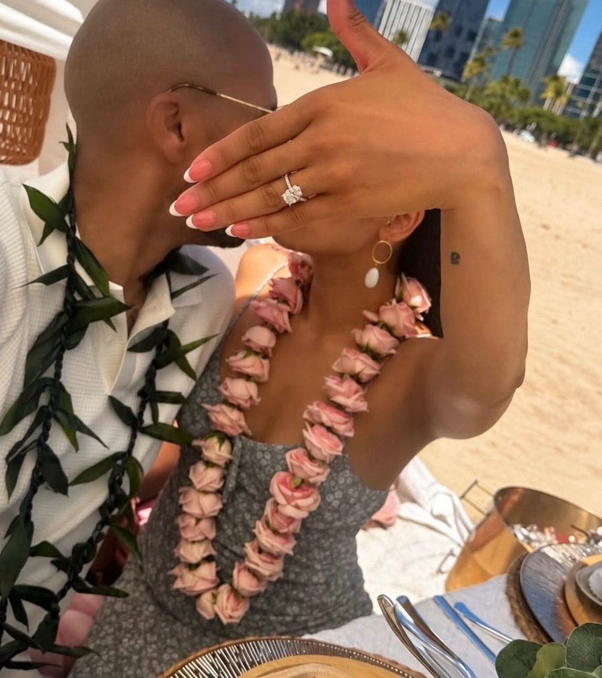 Newly engaged hands with the ring over the grazing table and skyline
