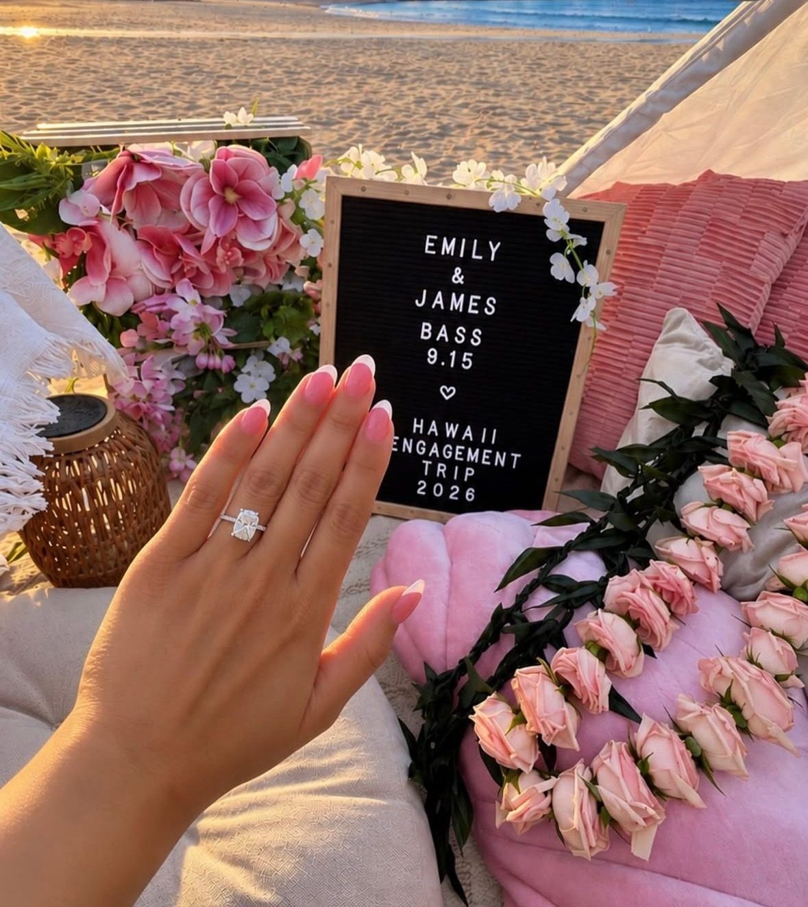 Engagement ring beside the custom letterboard and flower leis