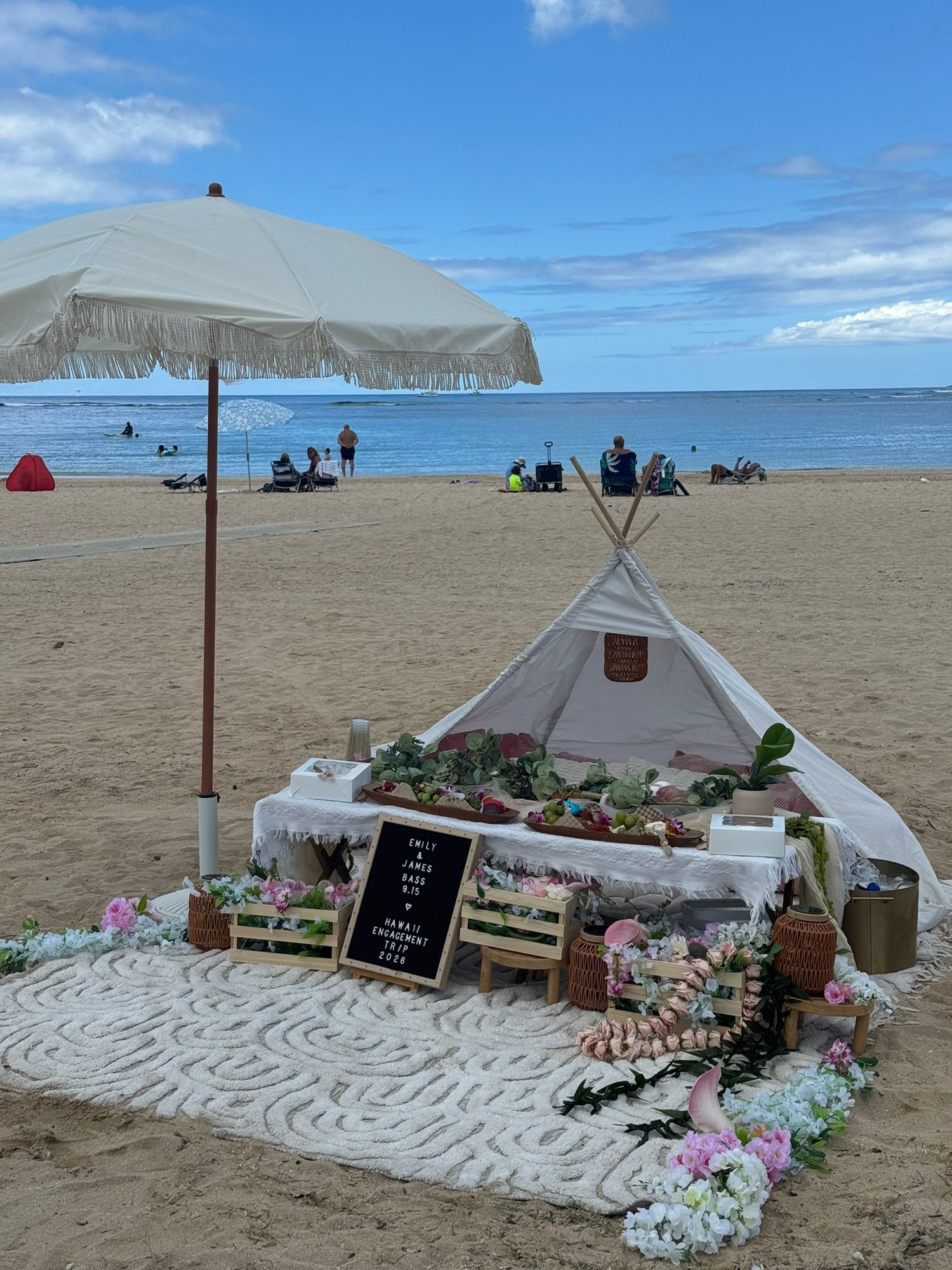 Teepee picnic setup with umbrella and grazing table, ready for the couple