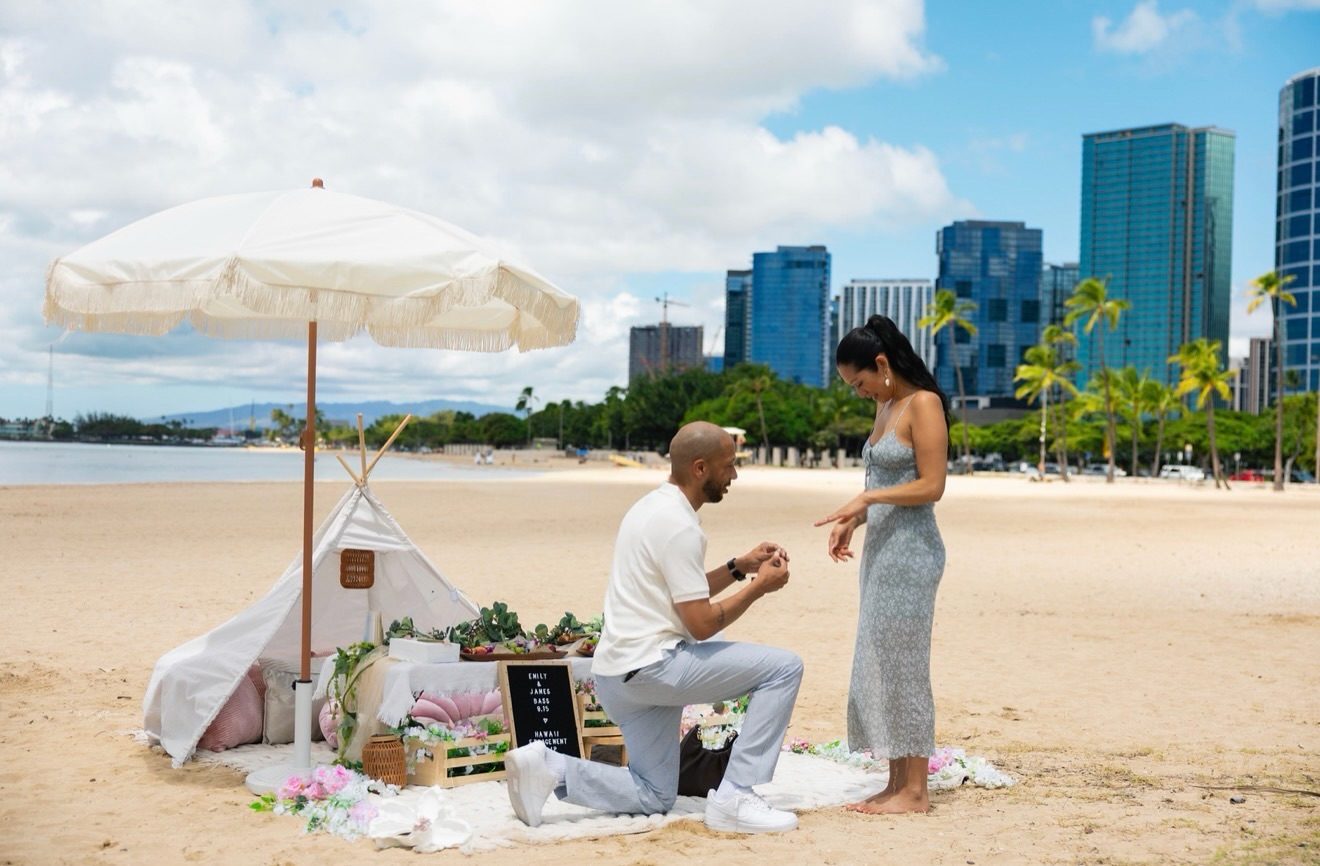 James proposes to Emily with the Honolulu skyline behind them