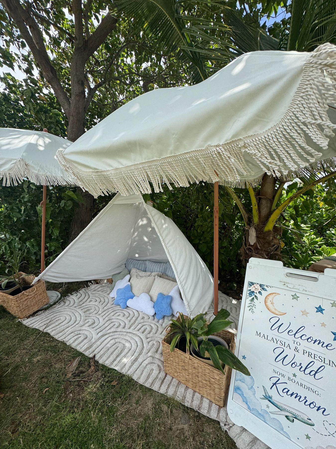 Garden baby shower picnic with a white teepee and welcome sign