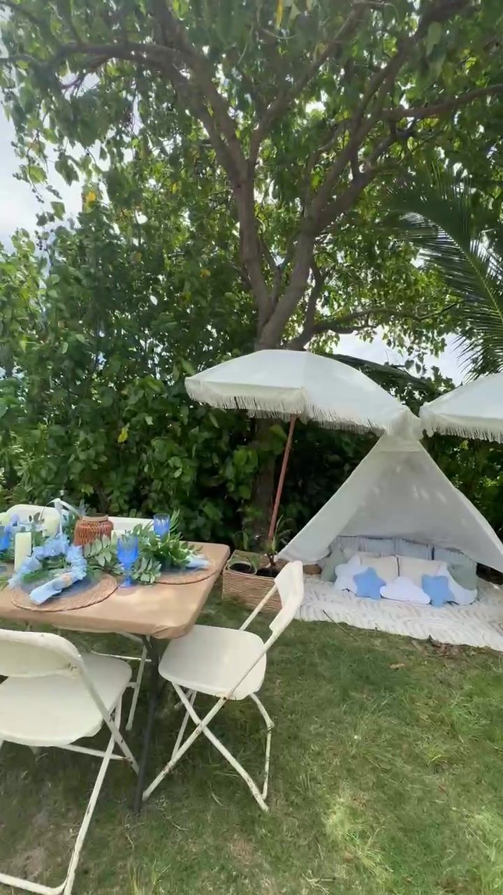 Long blue-and-white shower table set on the lawn under umbrellas