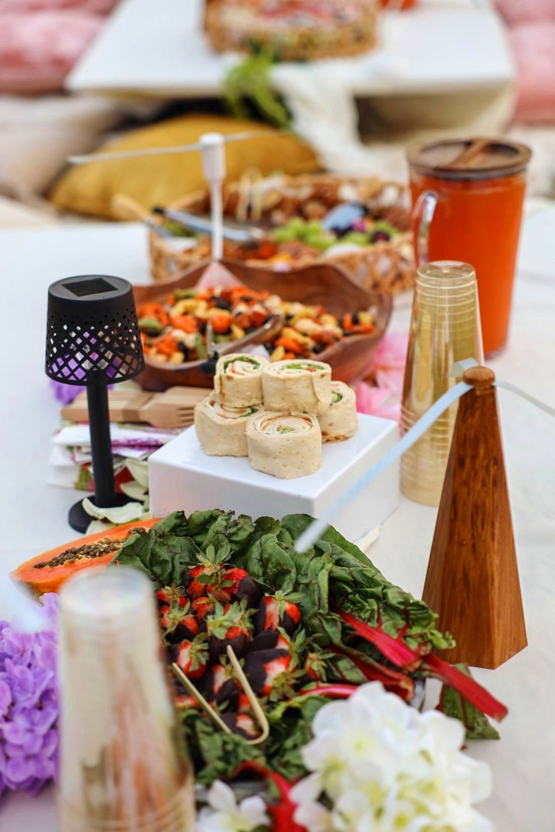 Fresh salads, fruit and juice spread across the white table