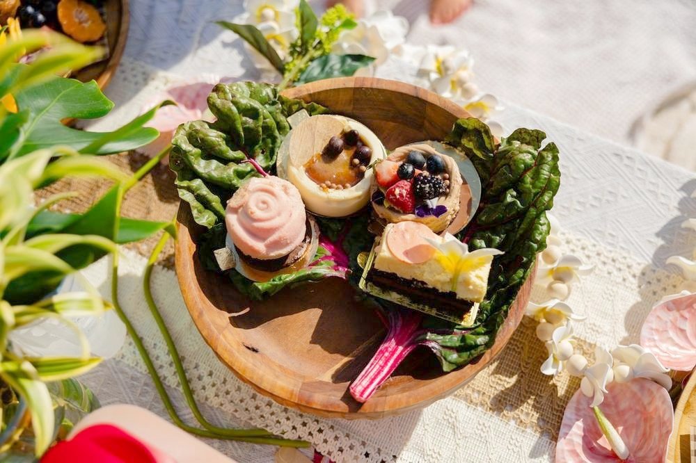 Rose-shaped desserts and berry tarts in a carved wooden bowl