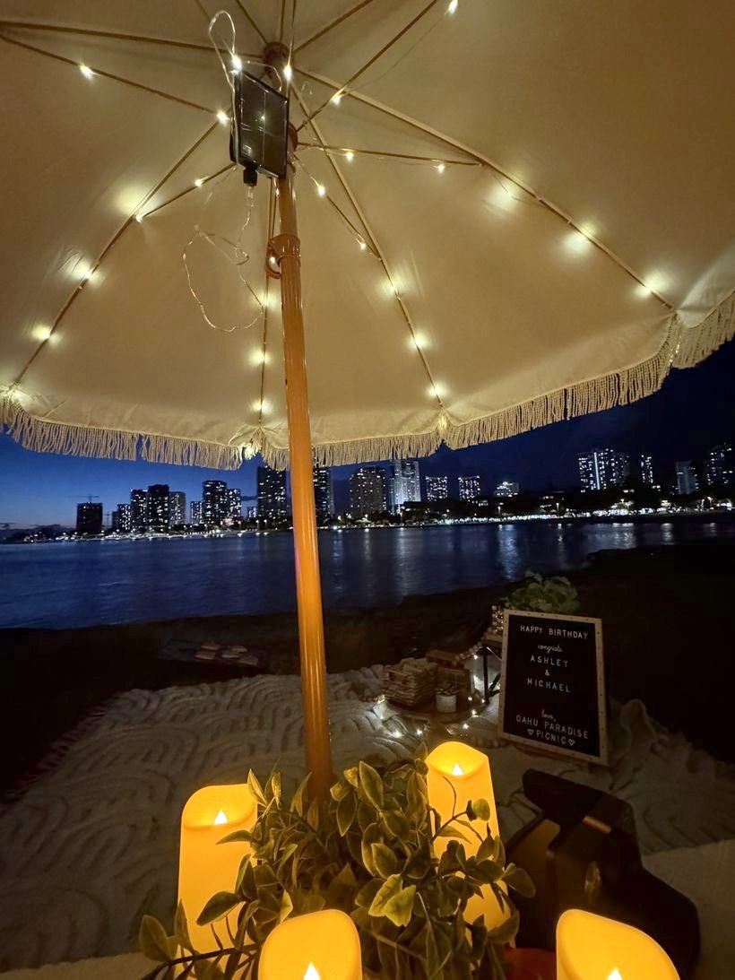 String lights glowing under the umbrella with the city lights after dark
